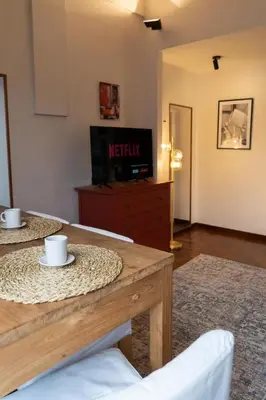 a living room with two tables and a tv at La Spezia House in Rome