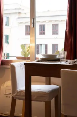 a table and chairs with a table and a window at La Spezia House in Rome
