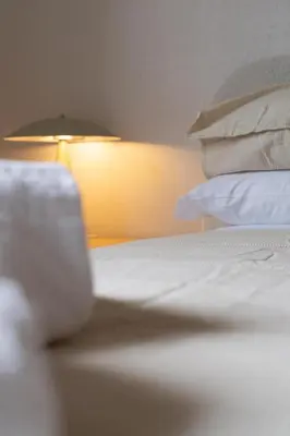 a bedroom with a bed with pillows and a lamp at La Spezia House in Rome