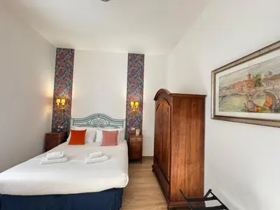 a bedroom with a bed and a painting on the wall at Cozy Place at Gianicolo in Rome