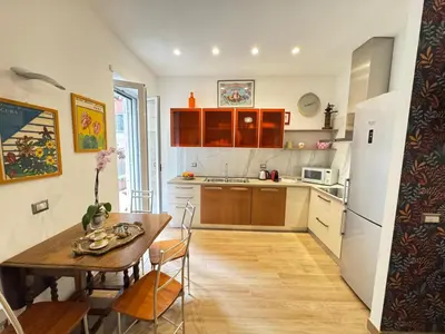 a kitchen with a wooden table and a kitchen with a refrigerator at Cozy Place at Gianicolo in Rome