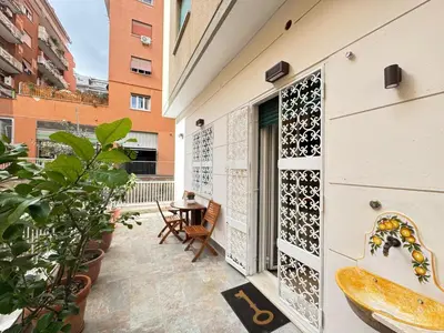 a balcony with a table and plants and a building at Cozy Place at Gianicolo in Rome