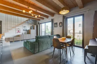 a living room with a green couch and a table at Modern Rooftop Apartment in Rome