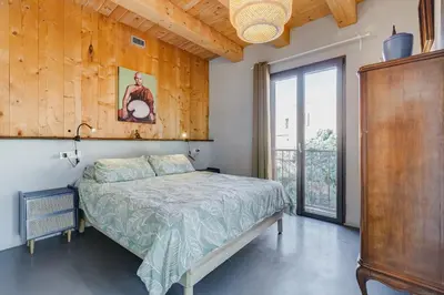 a bedroom with a bed and a large window at Modern Rooftop Apartment in Rome