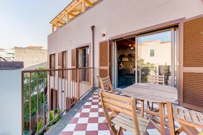 a patio with a table and chairs on a balcony at Modern Rooftop Apartment in Rome