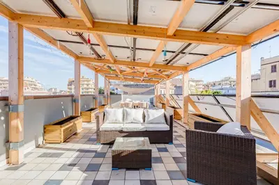 a balcony with chairs and a table on a roof at Modern Rooftop Apartment in Rome