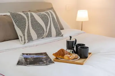 a bed with a tray of croissants and a plate of food at Urban Oasis with Terrace & free Parking, int11 in Rome