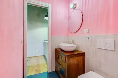 a pink bathroom with a sink and a mirror at garden studio apartment in Rome