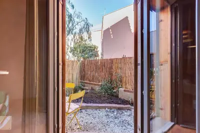 an open door to a backyard with a fence at garden studio apartment in Rome