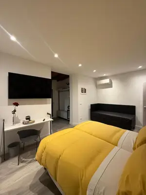 a bedroom with a yellow bed and a desk at FoffoSuite in Rome
