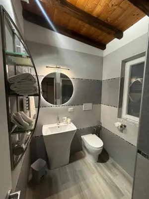 a bathroom with a toilet and a sink and a mirror at FoffoSuite in Rome