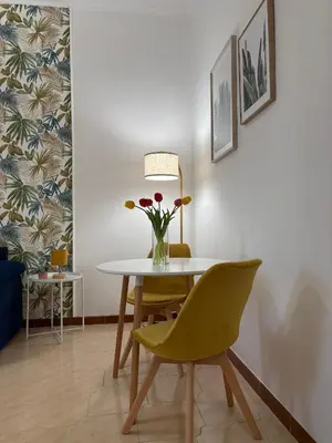 a dining room with a table and a vase of flowers at Cortile di Testaccio in Rome