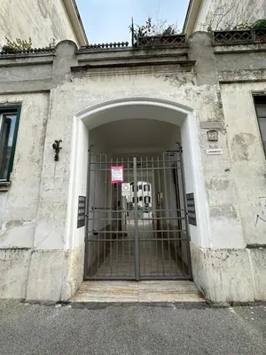 an entrance to a building with a gate at Cortile di Testaccio in Rome