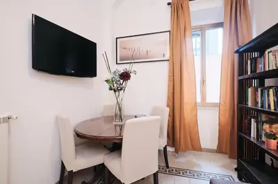 a dining room with a table and a tv on a wall at NEW - La Casetta di Nadia in Rome