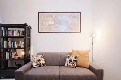 a couch in a living room with a book shelf at NEW - La Casetta di Nadia in Rome