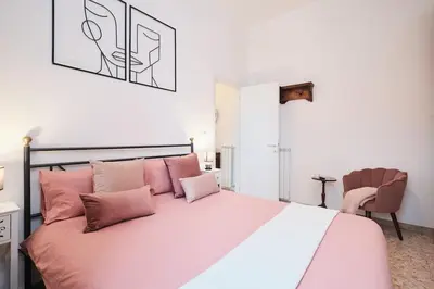a bedroom with a large bed with pink pillows at NEW - La Casetta di Nadia in Rome