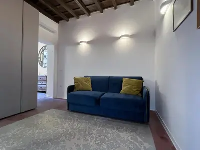 a blue couch in a living room with white walls at Regina Cappellari - Elegante dimora nel cuore di Roma in Rome