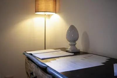 a desk with a lamp and a book on it at Regina Cappellari - Elegante dimora nel cuore di Roma in Rome