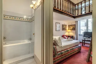 a bedroom with a tub and a bed with a chair at Corso Vittorio top location in Rome