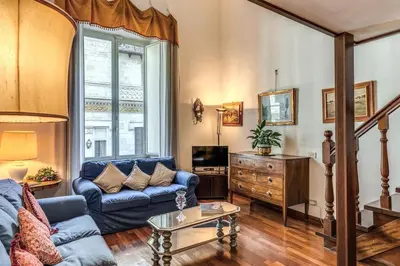 a living room with a blue couch and a tv at Corso Vittorio top location in Rome
