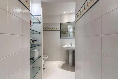 a bathroom with a sink and a toilet and a mirror at Corso Vittorio top location in Rome