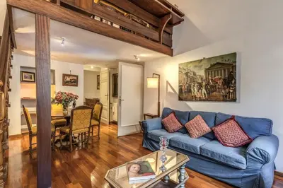 a living room with a blue couch and a table at Corso Vittorio top location in Rome