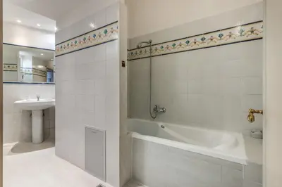 a white bathroom with a tub and a sink at Corso Vittorio top location in Rome