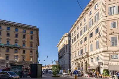 a city street with tall buildings on a sunny day at Corso Vittorio top location in Rome