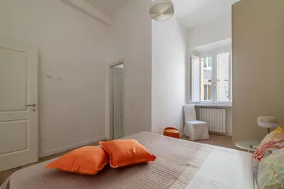 a bedroom with a bed with two orange pillows on it at Bright apartment Acquario Romano in Rome