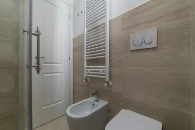 a bathroom with a toilet and a sink and a mirror at Bright apartment Acquario Romano in Rome