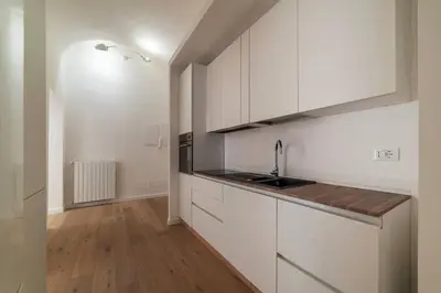 a kitchen with white cabinets and a sink at Bright apartment Acquario Romano in Rome