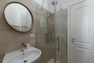 a bathroom with a sink and a mirror and a shower at Bright apartment Acquario Romano in Rome