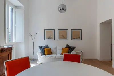 a living room with a white couch with orange pillows at Bright apartment Acquario Romano in Rome