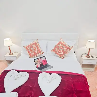 a bed with heart shaped pillows and a laptop on it at NEXT Palace in Rome