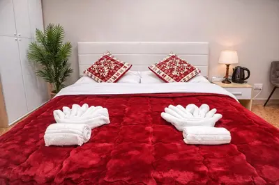 a bedroom with a red bed with towels on it at NEXT Palace in Rome