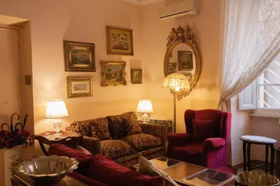 a living room with a couch and a chair and a mirror at Antonietta's Home in Rome
