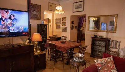 a living room with a table and a large screen television at Antonietta's Home in Rome