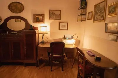 a room with a desk and a table with a lamp at Antonietta's Home in Rome