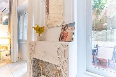 a room with a white fireplace with a window at Gianicolo Secret Garden Suite in Rome