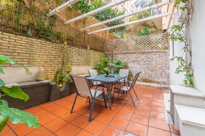 a patio with a table and chairs and a brick wall at Gianicolo Secret Garden Suite in Rome