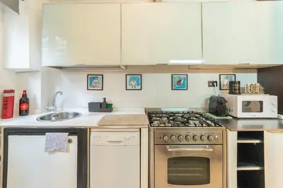 a kitchen with a stove and a microwave at Gianicolo Secret Garden Suite in Rome