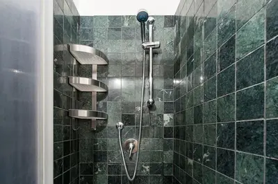 a bathroom with a shower with green tiles at Yellow Studio in Rome