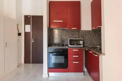 a kitchen with red cabinets and a microwave at Yellow Studio in Rome