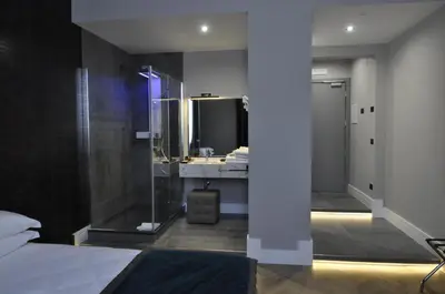 a bedroom with a bathroom with a sink and a mirror at Place 24 Suites & Wellness in Rome