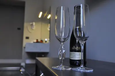 two wine glasses sitting next to a bottle of wine at Place 24 Suites & Wellness in Rome