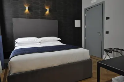 a bedroom with a large bed with white sheets and pillows at Place 24 Suites & Wellness in Rome