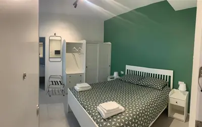 a bedroom with a bed and a green wall at Room A in Rome