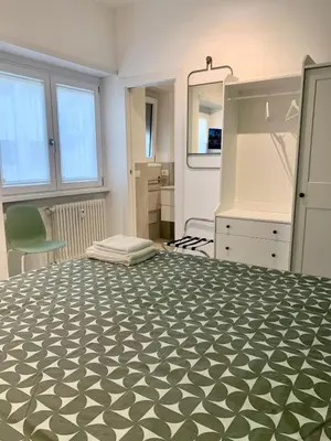 a bedroom with a large bed with a black and white bedspread at Room A in Rome