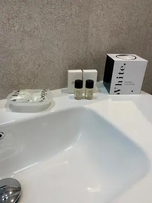 a white bathroom sink with a box and cosmetics at Room A in Rome