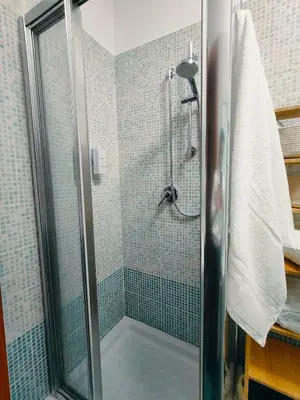 a shower in a bathroom with blue tiles at Milena's Home Rome Center in Rome